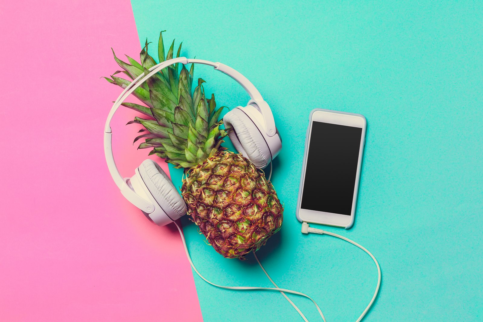 Für das richtige "Summer Feeling" darf eine neue Playlist nicht fehlen! Foto: © envato/FabrikaPhoto pineapple-on-colored-paper-in-headphones-2025-02-24-13-56-09-utc_1_